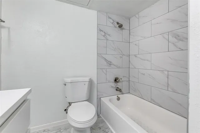 a white toilet and tub sitting next to a bathroom sink