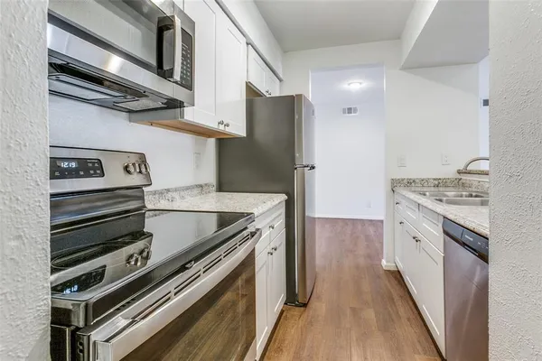 a kitchen with stainless steel appliances granite countertop a stove and a refrigerator