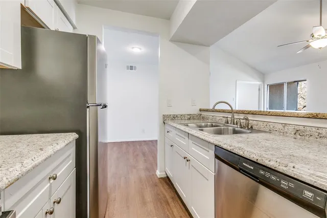 a kitchen with granite countertop a sink stove and refrigerator