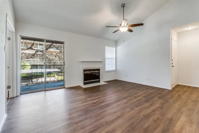 a view of empty room with wooden floor and fireplace