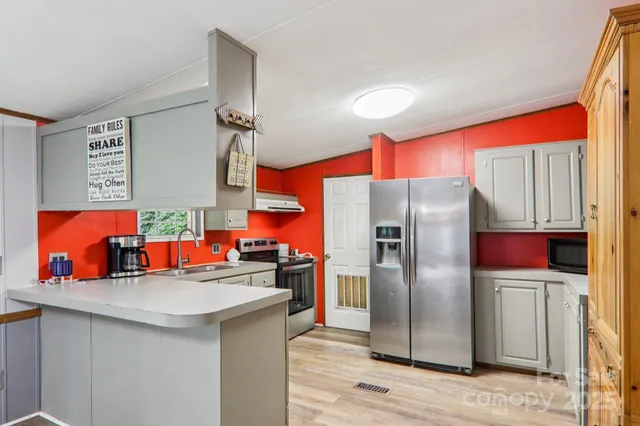 a kitchen with stainless steel appliances a sink and a refrigerator