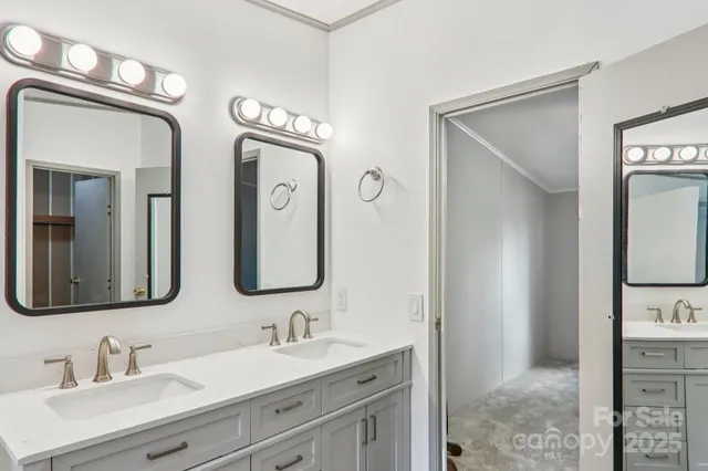 a bathroom with double vanity sinks and a mirror