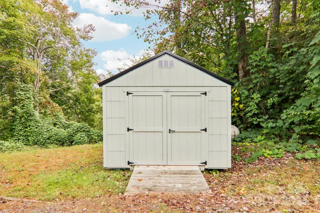 a view of a house with a yard and large tree