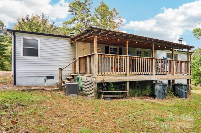 a view of a house with a wooden deck and a yard