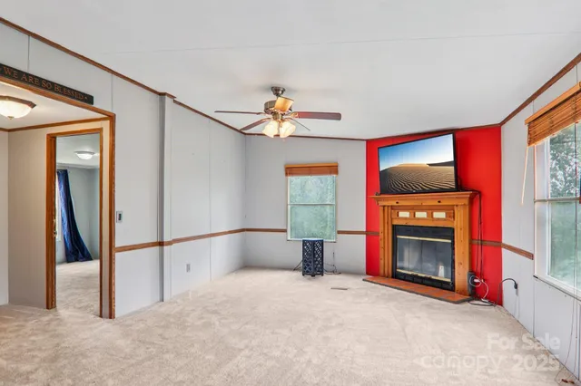 a view of an empty room with a fireplace and a window