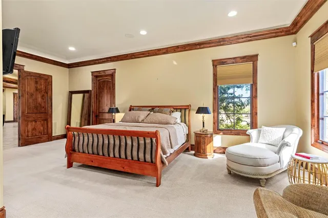 a spacious bedroom with a bed and glass window
