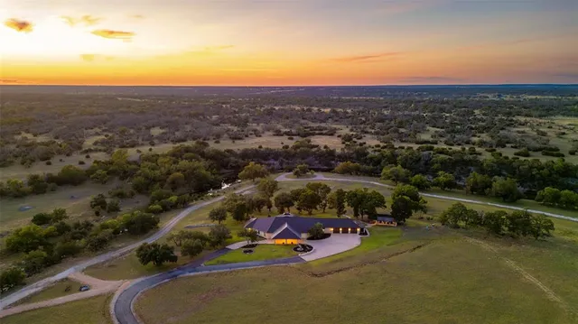 an aerial view of a house with a garden and lake view