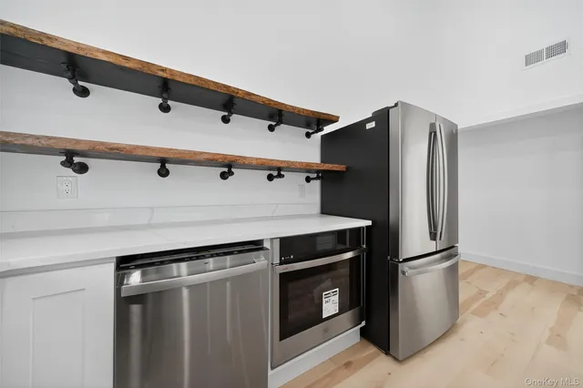 a kitchen with metallic refrigerator and microwave