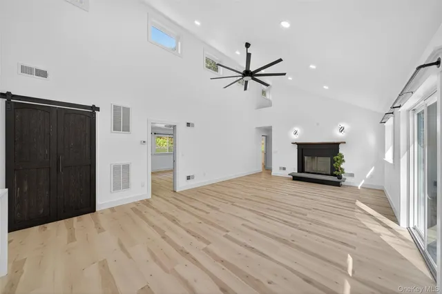a view of empty room with fireplace and wooden floor