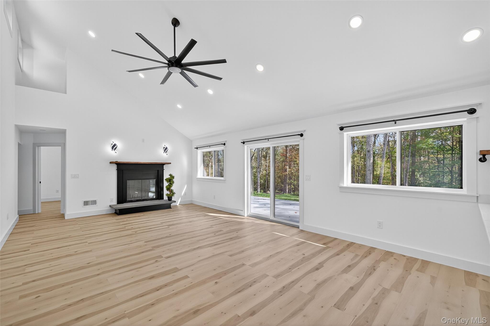 273 Perry Pond Road Narrowsburg, NY 12764 - Photo 19 of 49 Unfurnished living room featuring a glass covered fireplace, light wood-style floors, recessed lighting, high vaulted ceiling, and a ceiling fan