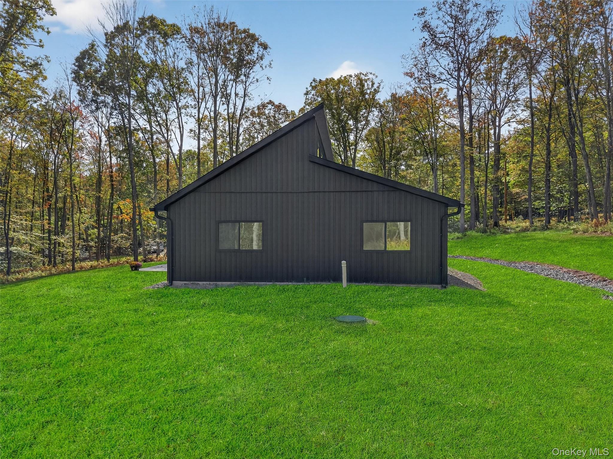 273 Perry Pond Road Narrowsburg, NY 12764 - Photo 38 of 49 View of side of home with a yard and board and batten siding