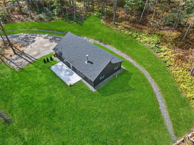 an aerial view of a house with a yard and trees all around