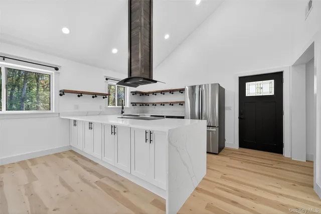 a kitchen with stainless steel appliances cabinets and a wooden floor