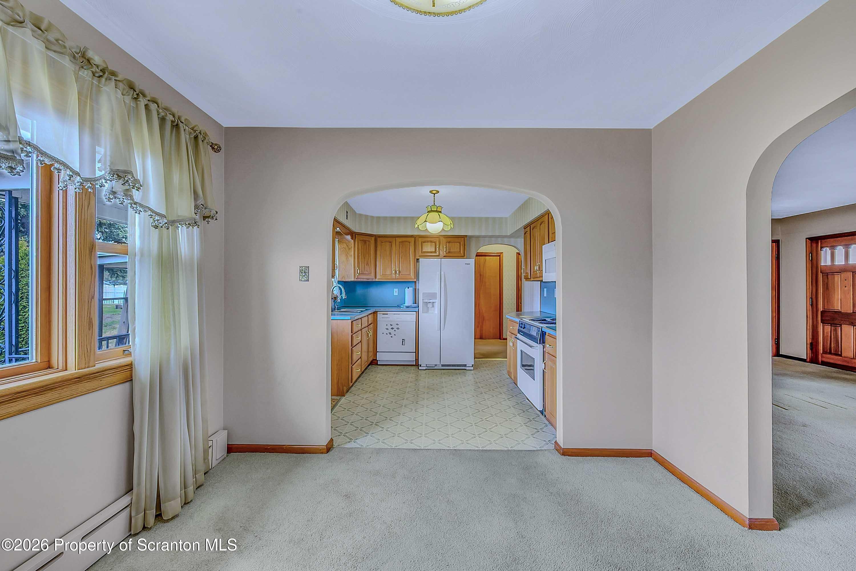 211 Green Street Dunmore, PA 18512 - Photo 7 of 38 an empty room with a fireplace and a chandelier