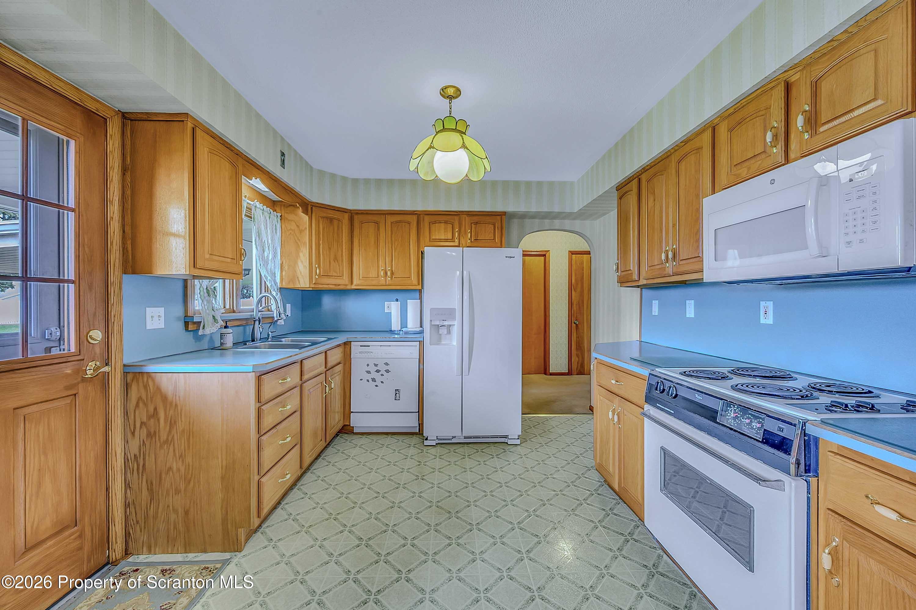 211 Green Street Dunmore, PA 18512 - Photo 8 of 38 a kitchen with granite countertop a sink cabinets stainless steel appliances and a window