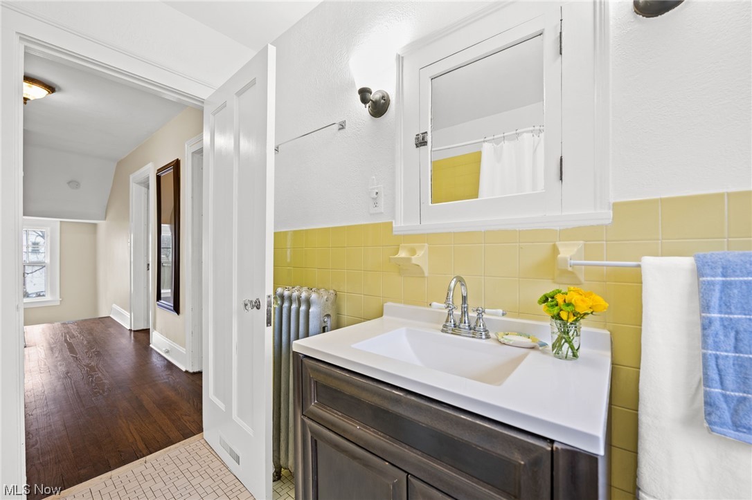 12727 Cedar Road Cleveland Heights, OH 44106 - Photo 25 of 32 Bathroom with tile walls, tile flooring, radiator heating unit, vanity, and backsplash