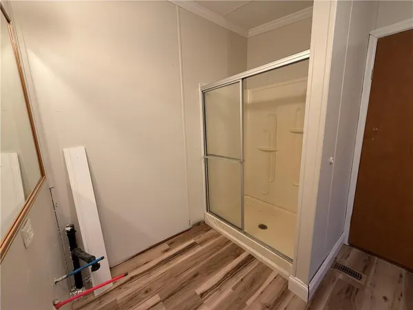 a view of a room with wooden floor and white walls