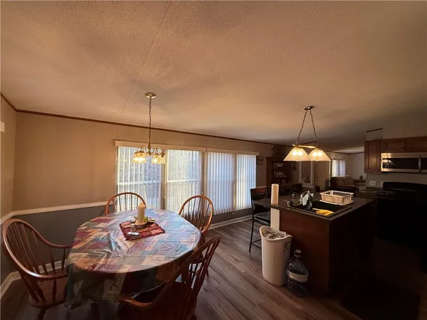 a dining room with furniture a chandelier and wooden floor
