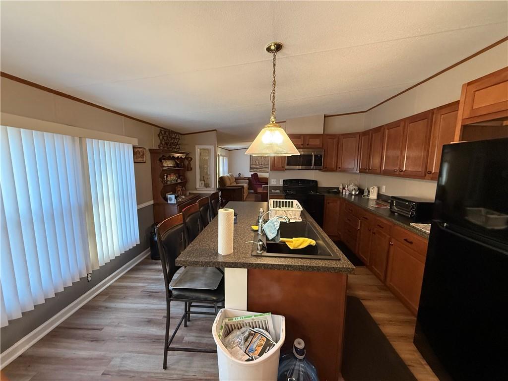 1106 Gary Road Rockwood, PA 15557 - Photo 10 of 46 a kitchen with a refrigerator a stove a sink dishwasher a dining table and chairs with wooden floor