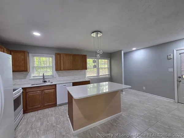 a large kitchen with kitchen island a sink stainless steel appliances and cabinets