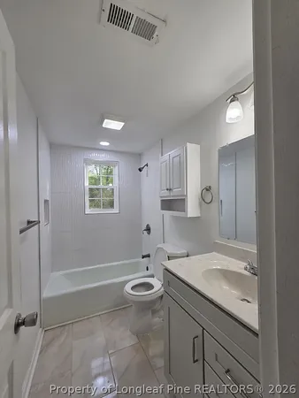 a bathroom with a granite countertop sink a toilet and shower