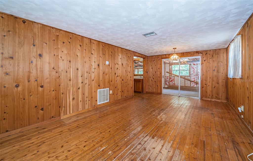 6423 Bass Road Weeki Wachee, FL 34607 - Photo 11 of 49 a view of empty room with wooden floor and fan