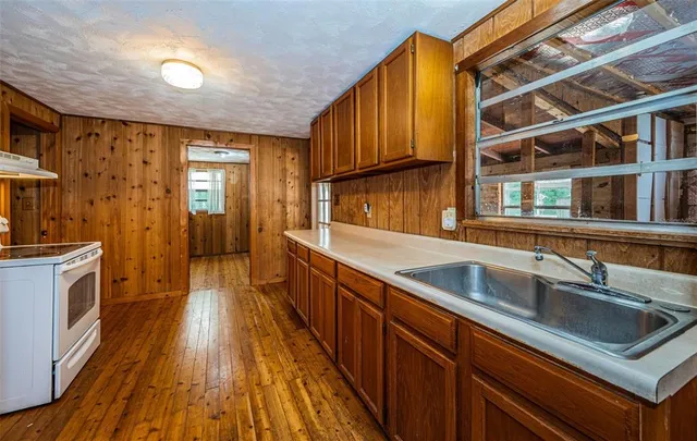 a kitchen with stainless steel appliances granite countertop a sink and wooden cabinets