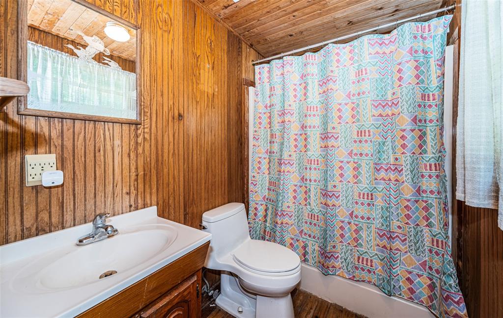 6423 Bass Road Weeki Wachee, FL 34607 - Photo 21 of 49 a bathroom with a sink toilet and shower curtain