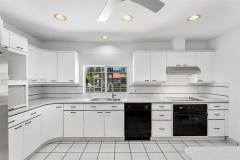 a kitchen with a stove sink and cabinets