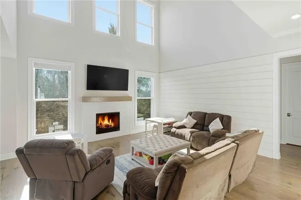a living room with furniture a fireplace and a flat screen tv