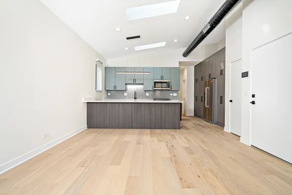 a large kitchen with kitchen island a sink stainless steel appliances and cabinets