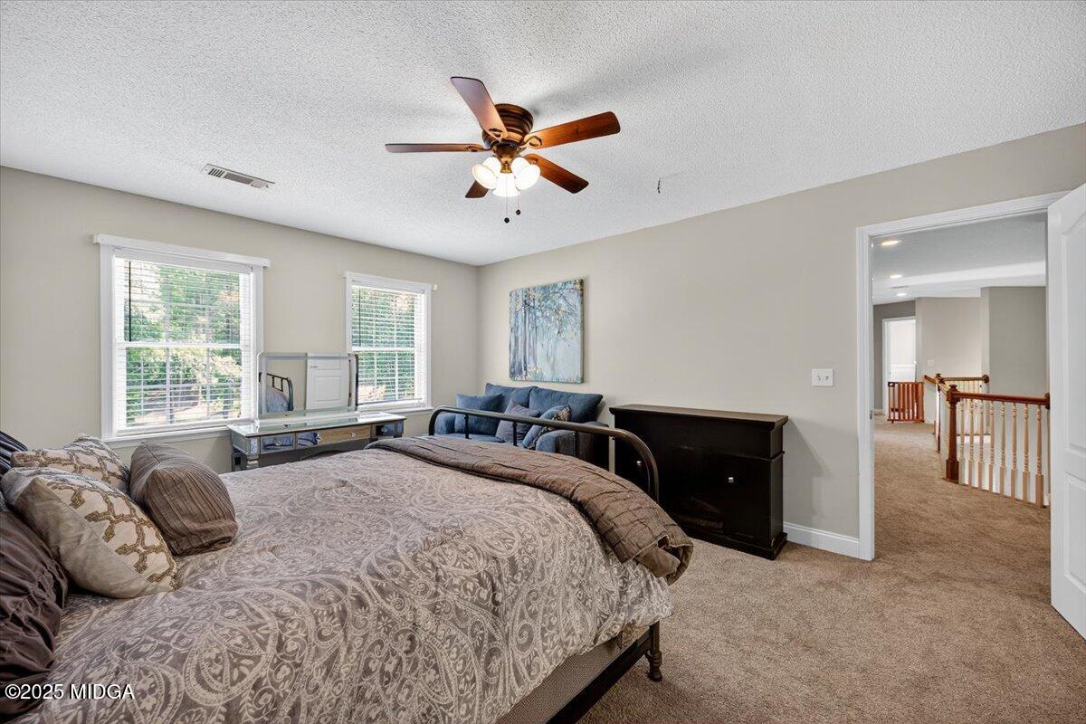 9481 Hopewell Road Musella, GA 31066 - Photo 28 of 72 a spacious bedroom with a large bed and a chandelier