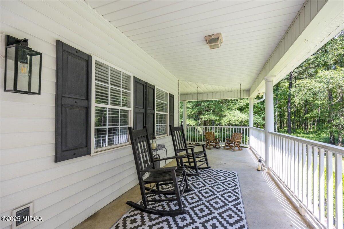 9481 Hopewell Road Musella, GA 31066 - Photo 3 of 72 a view of a porch with furniture and wooden floor