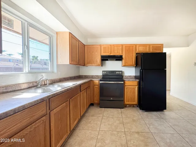 a kitchen with granite countertop a refrigerator and a sink
