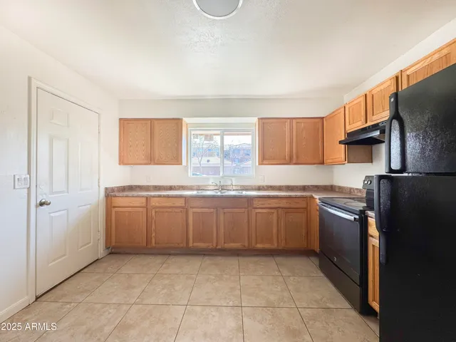 a kitchen with a sink a refrigerator and cabinets
