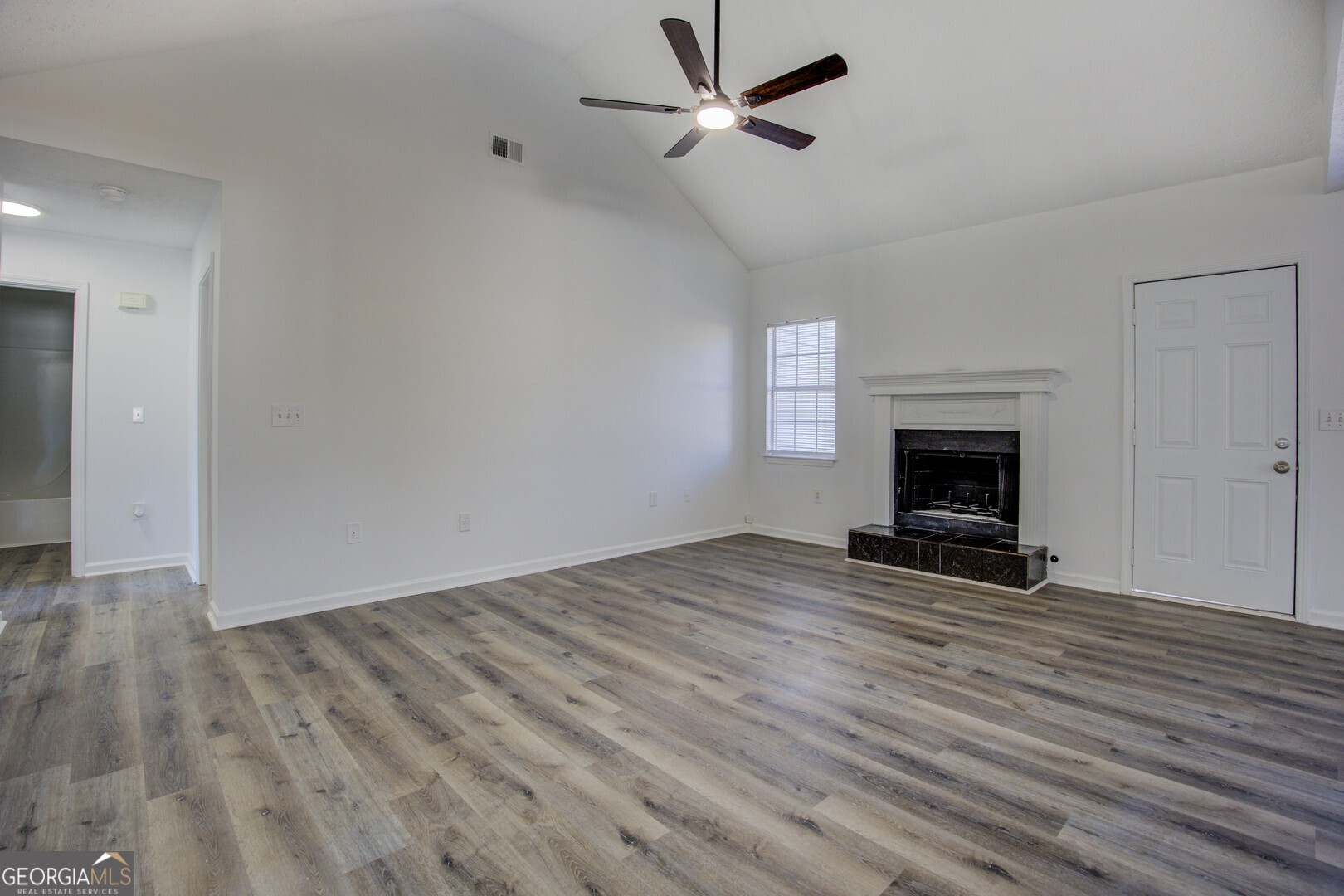40 Brandon Drive Covington, GA 30016 - Photo 12 of 40 an empty room with wooden floor a fireplace and windows