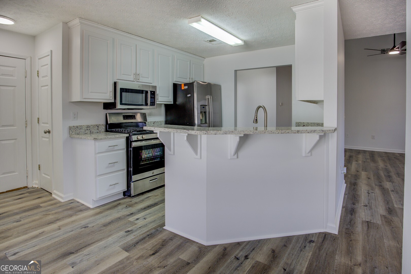 40 Brandon Drive Covington, GA 30016 - Photo 18 of 40 a view of a kitchen with stainless steel appliances a refrigerator and a stove top oven