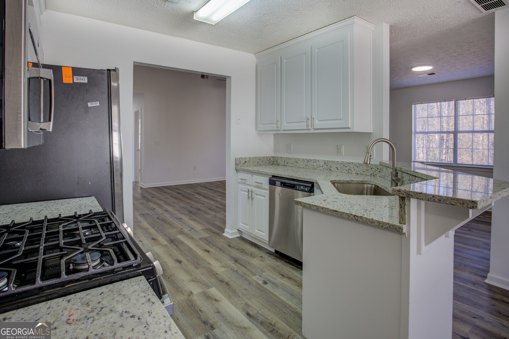 40 Brandon Drive Covington, GA 30016 - Photo 21 of 40 a kitchen with granite countertop a sink stove and cabinets
