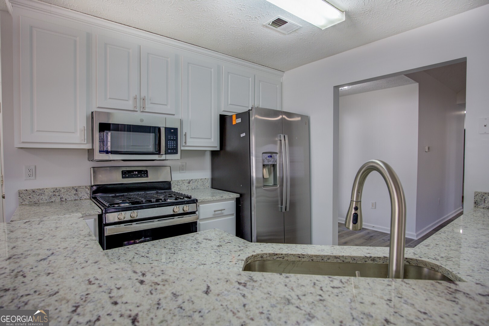 40 Brandon Drive Covington, GA 30016 - Photo 22 of 40 a kitchen with stainless steel appliances granite countertop a refrigerator and a stove top oven