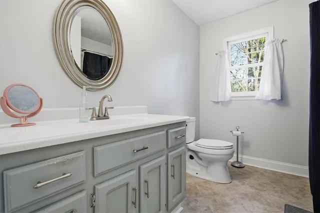 a bathroom with a toilet a sink and a mirror
