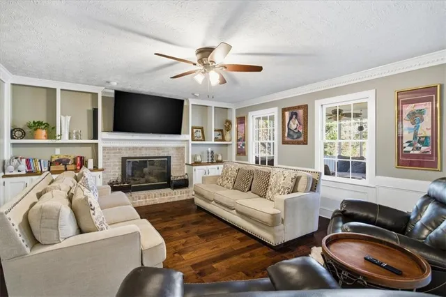 a living room with furniture a fireplace and a flat screen tv