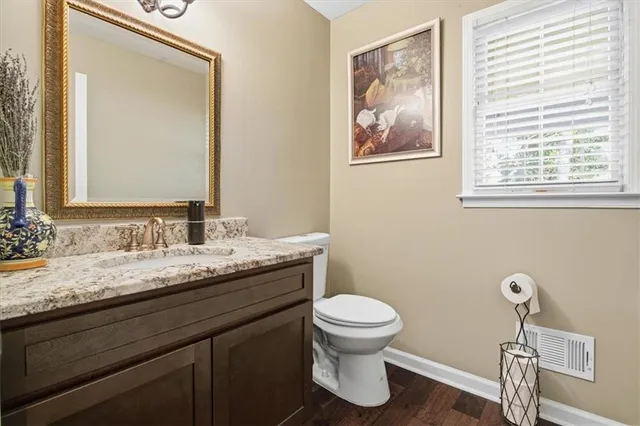 a bathroom with a granite countertop toilet sink and mirror