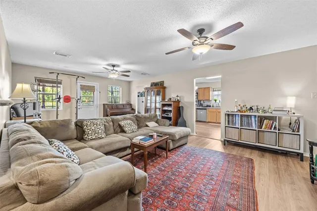 a living room with furniture and view of kitchen