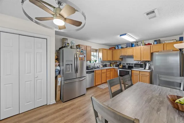 a kitchen with stainless steel appliances granite countertop a refrigerator a stove and a sink