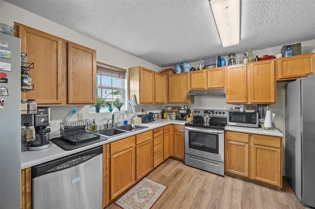 a kitchen with a sink stove top oven and cabinets