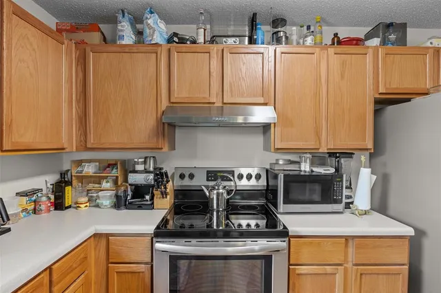 a kitchen with granite countertop a stove sink and cabinets