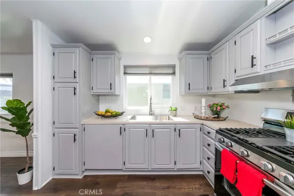 a kitchen with granite countertop a sink a stove and cabinets