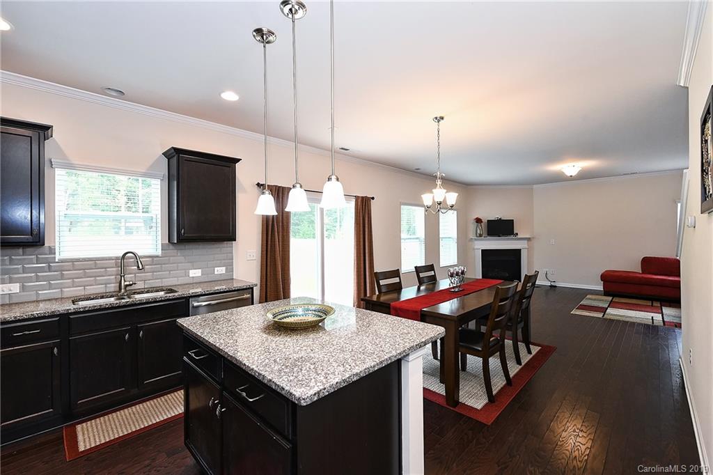 1580 Spring Blossom Trail Fort Mill, SC 29708 - Photo 11 of 22 a kitchen with a kitchen island a sink dining table and chairs