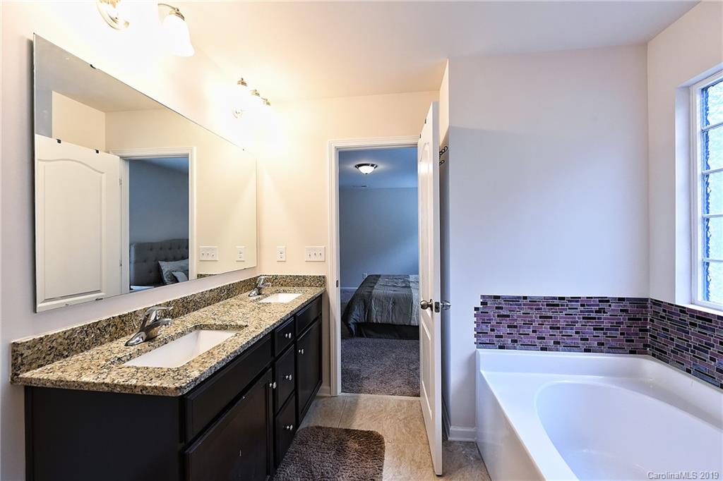 1580 Spring Blossom Trail Fort Mill, SC 29708 - Photo 16 of 22 a en suite bathroom with a granite countertop tub and a sink