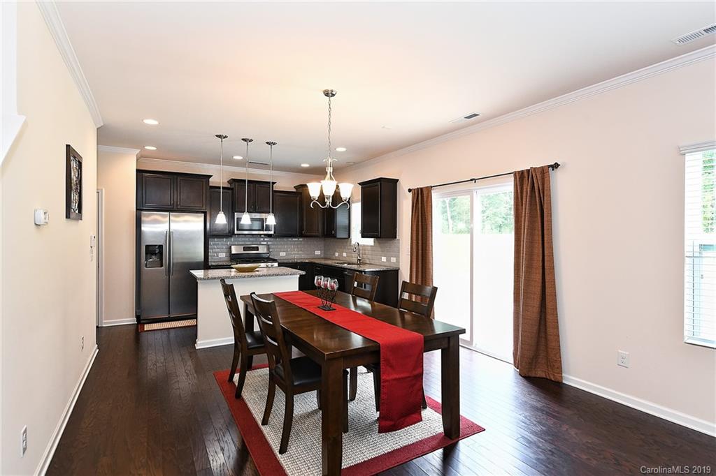 1580 Spring Blossom Trail Fort Mill, SC 29708 - Photo 9 of 22 a view of a dining room with furniture a kitchen and chandelier
